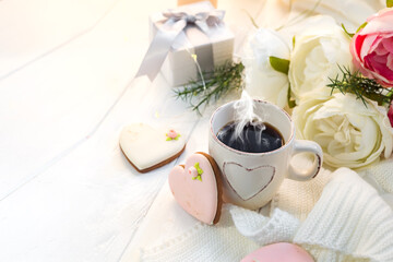 Heart cookies with cup of coffee on wooden background with plaid, copy space