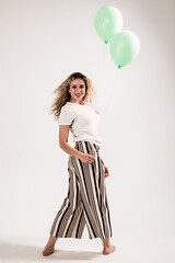 Curly girl with balloons on white background