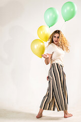 Curly girl with balloons on white background