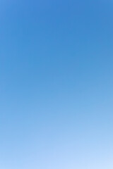 clear blue sky. gradient from dark to light. vertical