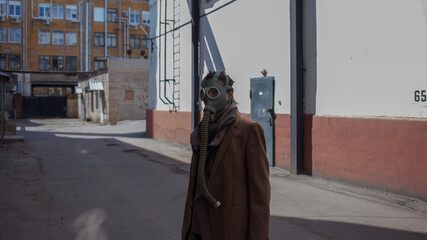 a woman walks down a gloomy street in a gas mask, mass infections and environmental problems, concept.