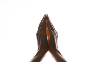 Praying hands on a white background. Light from above. Hands folded in prayer. Hand gestures