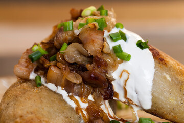 traditional Lithuanian dish served with sour cream and fried bacon