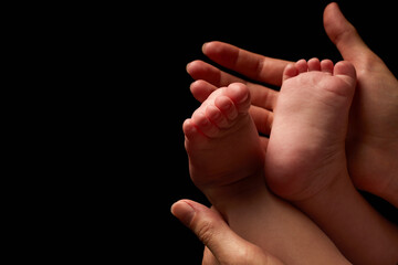 Close up newborn fingers feet and hands isolated on black background 