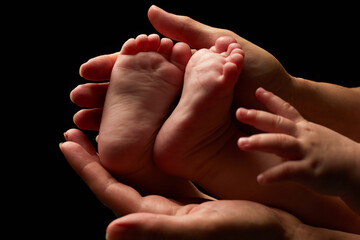 Close up newborn fingers feet and hands isolated on black background 
