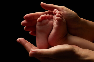 Close up newborn fingers feet and hands isolated on black background 