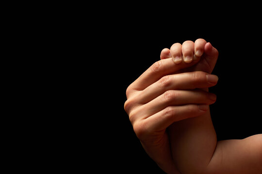 Close up newborn fingers feet and hands isolated on black background 