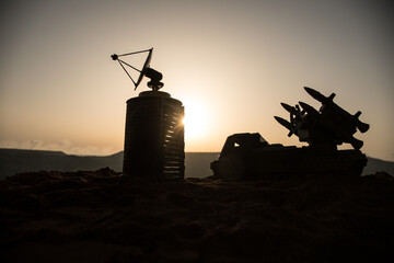 Creative artwork decoration. Silhouette of mobile air defence truck with radar antenna during...