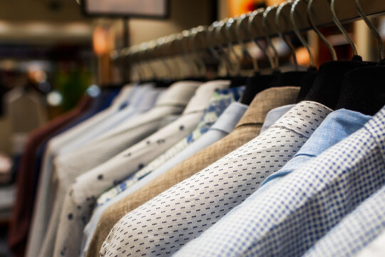 Shirts shopping close-up on hangers. Men's clothing store with a variety of autumn-winter goods to choose from. The range of goods in the boutique. The concept of sales, promotions, Black Friday
