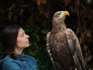 A young woman with a huge mountain eagle on her glove,