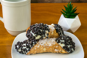 two chocolate chip cannolis with coffee