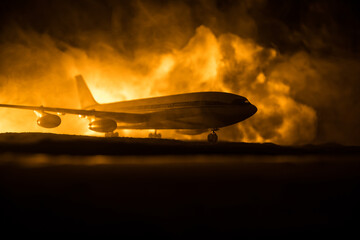 Air Crash. Burning falling plane. The plane crashed to the ground. Decorated with toy at dark fire...