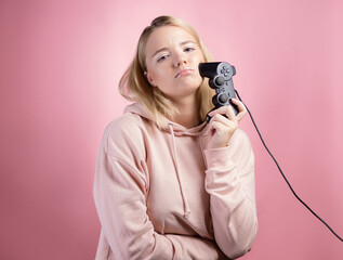 A gamer who is passionate about the process. A cute blonde is holding a gamepad © Alexander