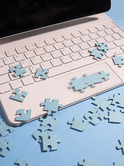 Puzzle elements on a laptop keyboard, software development, concept.