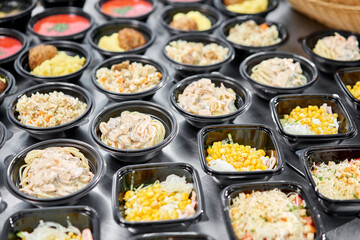 Food delivery. Different in plastic disposable lunch box with healthy natural food. Chicken broth, mashed soup, mashed potatoes with cutlet, seafood pasta, salads, pilaf with a fresh bun.