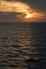 A sunset peaks through the clouds over the Mediterranean.