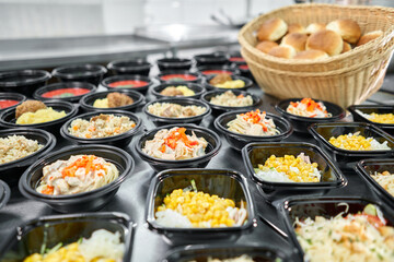 Row of plastic disposable lunch box with healthy natural food. Soups, cream soup, main course with side dish, salads. Food delivery. Lunch in the office.