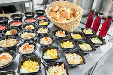 Row of plastic disposable lunch box with healthy natural food. Soups, cream soup, main course with side dish, salads. Food delivery. Lunch in the office.