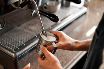small business, people and service concept. Bartender in apron with holder and tamper preparing coffee at coffee shop