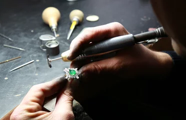 Poster Jewelry workshop. Jeweler holding a diamond emerald ring © kamil