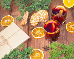 Mulled wine and spices on a wooden background with branches of a Christmas tree. Selective focus