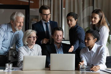 Effective teamwork. Older and younger men women multiracial business executives colleagues gather...