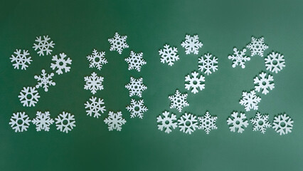 Fototapeta na wymiar Christmas figures 2022 on a green background of figures of Christmas trees and snowflakes ,the concept of Christmas and new year with a place for text