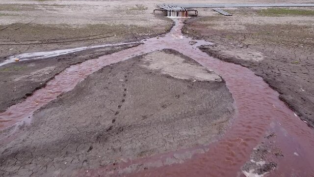 Shooting from a copter. Dirty water flows through a pipe. Pollution of the environment and water bodies. Ecological catastrophe.