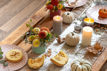 Fototapeta na wymiar Festive table setting with pumpkins and chrysanthemum flowers.