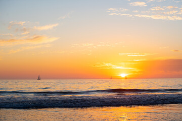 Naklejka na ściany i meble Sunset at the sea. Sunrise at beach. Colorful ocean beach sunrise.