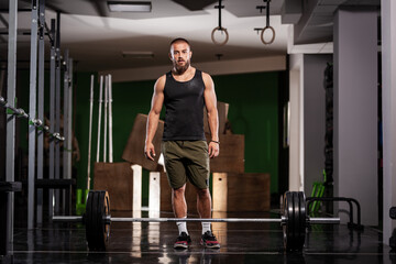 Obraz na płótnie Canvas Athlete preparing for weightlifting. Muscular man posing in fitness studio