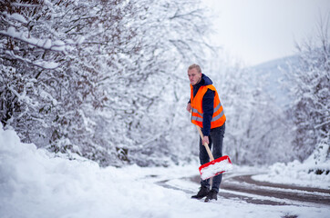 Fototapeta na wymiar Young man cleaning snow road