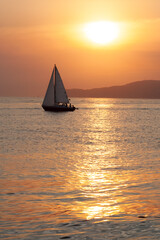 Obraz na płótnie Canvas Sailboat sailing in a beautiful summer sea during sunset