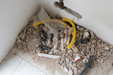 Home demolition. Broken pottery on the floor and eletricity conduit.