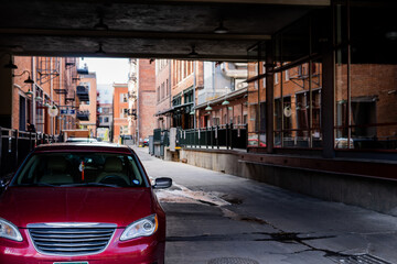 red car in a alley between red buildings © colmenadigital