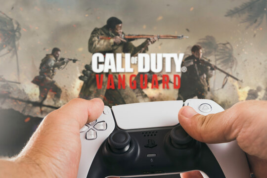 Male hand holding a Playstation 5 Dual Sense Controller with Call of Duty Vanguard game blurred in the background. Rio de Janeiro, RJ, Brazil. October 2021