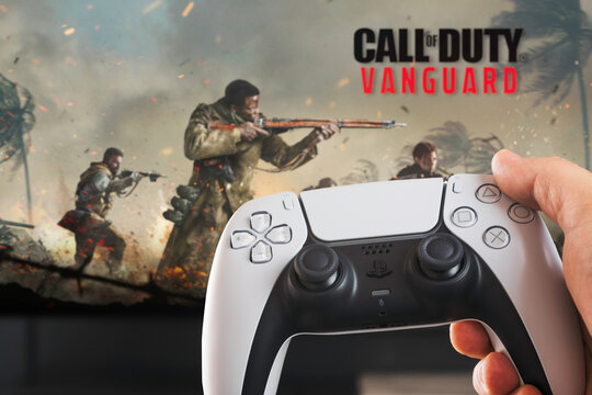 Male hand holding a Playstation 5 Dual Sense Controller with Call of Duty Vanguard game blurred in the background. Rio de Janeiro, RJ, Brazil. October 2021