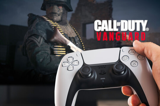 Male hand holding a Playstation 5 Dual Sense Controller with Call of Duty Vanguard game blurred in the background. Rio de Janeiro, RJ, Brazil. October 2021