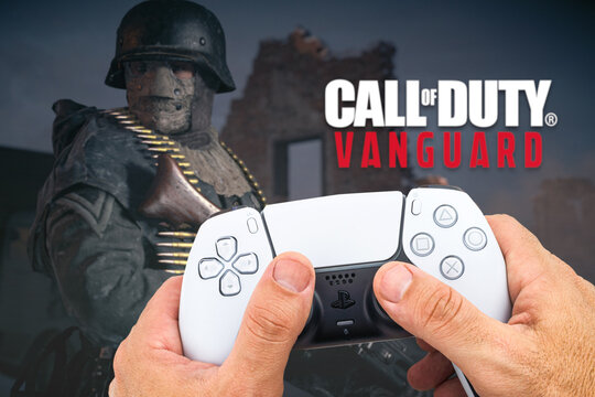 Male hand holding a Playstation 5 Dual Sense Controller with Call of Duty Vanguard game blurred in the background. Rio de Janeiro, RJ, Brazil. October 2021