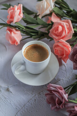 Coffee cup with rose flower on white table background. Valentine day with place for text. Vintage photo. Space for text
