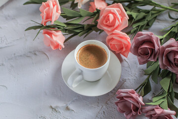 Coffee cup with rose flower on white table background. Valentine day with place for text. Vintage photo. Space for text