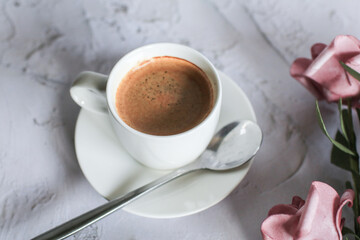 Coffee cup with rose flower on white table background. Valentine day with place for text. Vintage photo. Space for text