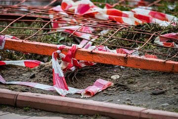 Broken warning tape. Aftermath of public unrest in  city. Destroyed barricades and fences.