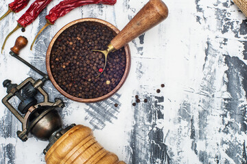 Pepper mill with chili peppers and chili on a light background. Flat lay top view.