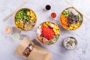 three salad pokes on a white marble background, Asian food from Hawaii, chopsticks, carrot, beans, pineapple, soy, jicama, seaweed