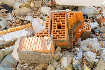 Close-up of red brick debris, plastic waste and other construction waste in an illegal landfill....
