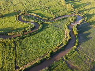Streams meander in agricultural areas during the rainy season with plenty of water. Green and warm in the morning sunshine.