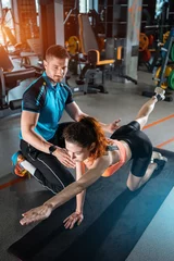 Türaufkleber young woman exercising quadruplex with personal trainer in gym © goami