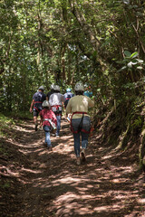 Grupo de personas caminando por senderos con equipo de seguridad para hacer canopy