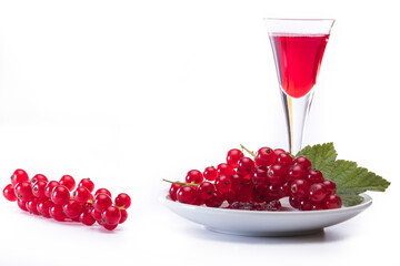 red currant on plate with glass of red juice